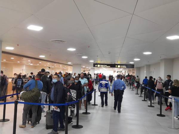 Viajeros en la zona de Migración de aeropuerto.