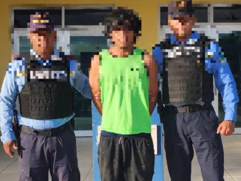 Agentes policiales y el hombre tras la detención.