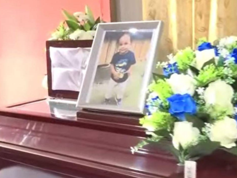 El niño de 2 años es velado en la sala de su casa.