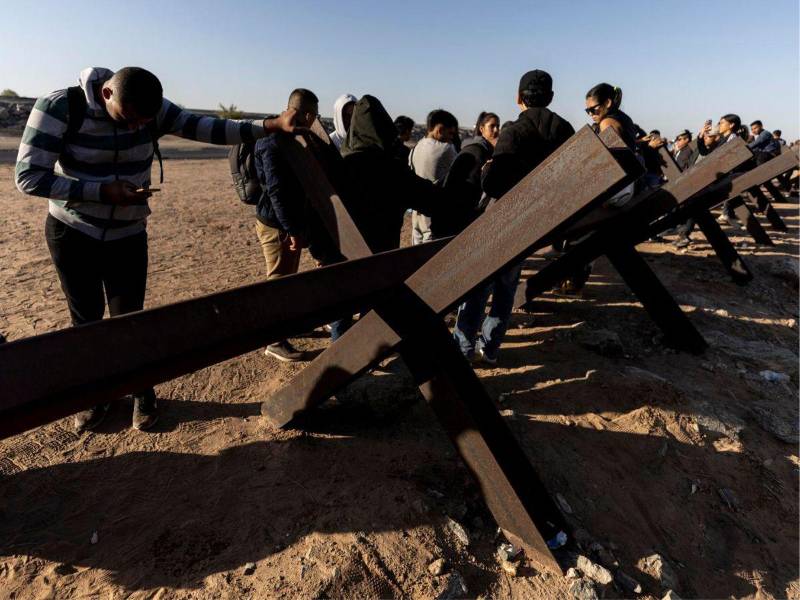 Migrantes esperan a ser procesados por agentes de la Patrulla Fronteriza de Estados Unidos tras cruzar ilegalmente en EE.UU., en Yuma, Arizona.