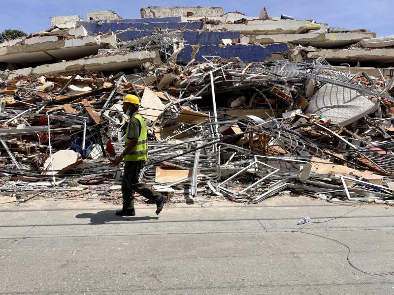 Un hombre camina frente a escombros de una edificación derrumbada por terremotos este jueves, en La Guaira (Venezuela).