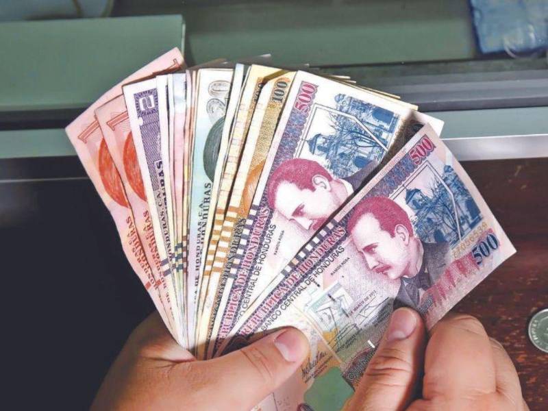 Hondureño cuenta lempiras en una entidad bancaria.
