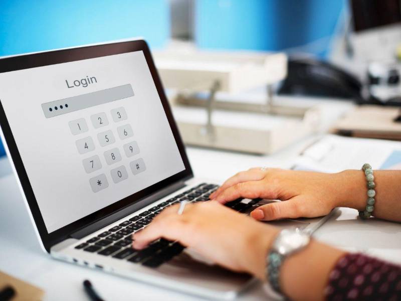 Una persona escribe la contraseña de su laptop.