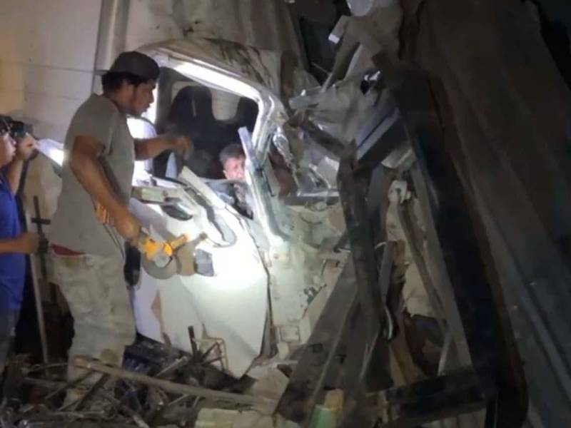 Cuerpos de bomberos realizan labores de rescate tras el accidente de un camión que se estrelló contra una vivienda en Taulabé, liberando a las personas atrapadas.
