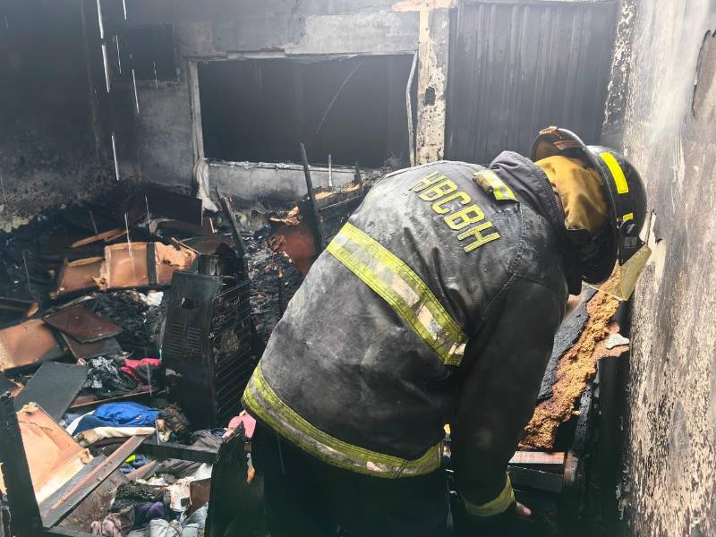 Miembro del Cuerpo de Bomberos inspecciona la vivienda afectada por las llamas.