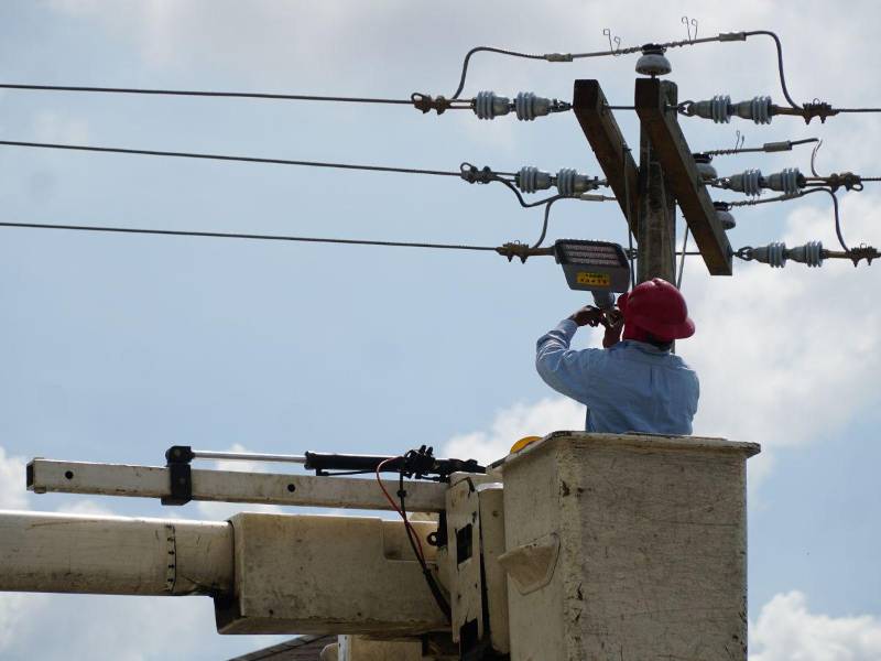 Un técnico de la Enee realiza instalación de lamparas en San Pedro Sula.