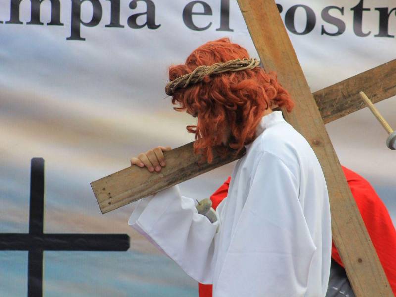 Imagen de Jesús cargando la cruz encabeza la procesión del viacrucis, recordando el camino al Calvario.