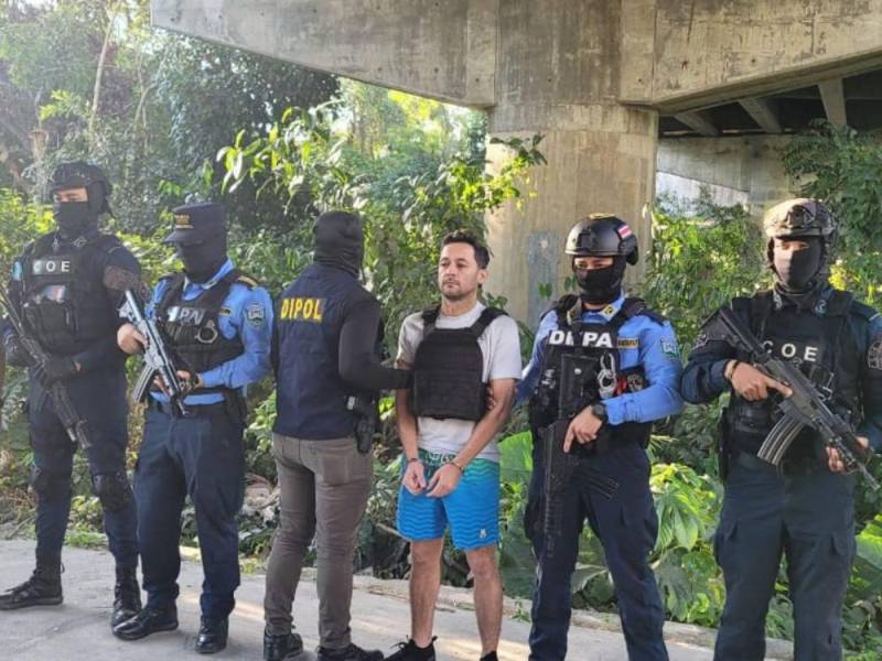 Fotografía de Jorge Luis Aguilar custodiado por agentes de la Policía, instantes después de su captura, el 8 de febrero de 2024 en San Pedro Sula, Honduras.