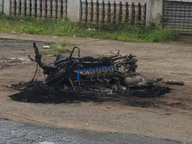 Los restos de una moto incendiada reflejan los fuertes enfrentamientos entre campesinos y grupos de Quebrada de Arena.