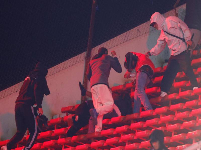 Fanáticos de Independiente y la Universidad de Chile se enfrentan este miércoles en una tribuna del Estadio Libertadores de América de la ciudad argentina de Avellaneda. EFE/ Juan Ignacio Roncoroni