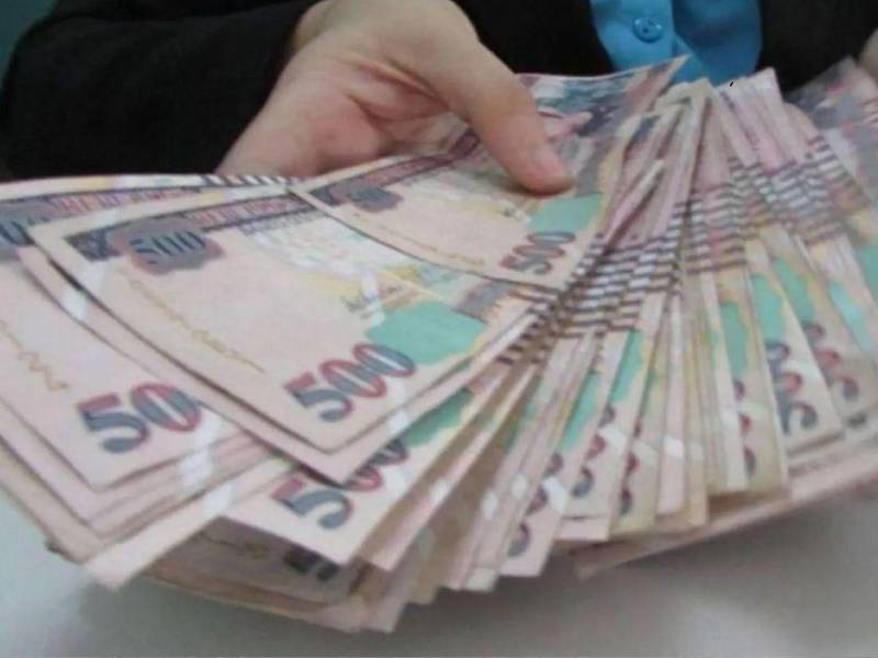 Persona entregando varios billetes de quinientos lempiras.