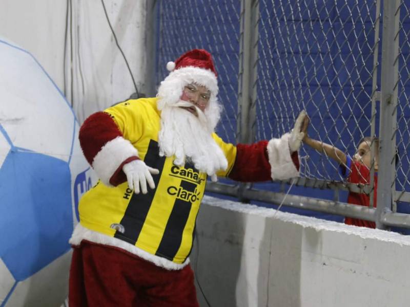 Visita especial en el estadio Morazán: El querido Santa Claus con la camiseta del Real España junto a un pequeño.