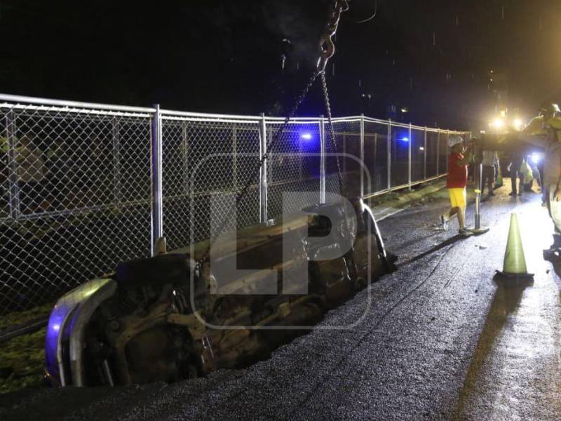 Elementos del Cuerpo de Bomberos, en conjunto con personal de la alcaldía de San Pedro Sula, retiraron la noche de este viernes el vehículo que cayó en un socavón formado por las intensas lluvias que azotaron la ciudad.