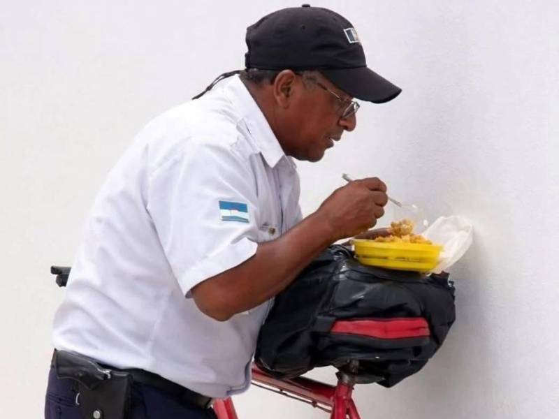 Hace unos días se viralizaron imágenes de un guardia de seguridad comiendo sobre una mochila colocada en la montura de su bicicleta.