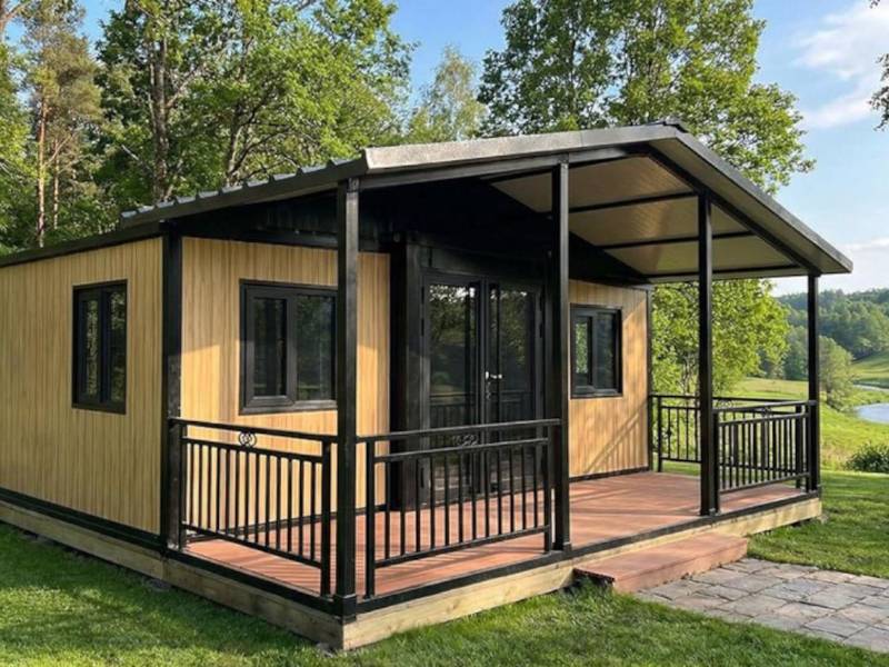 Uno de los modelos de casas prefabricadas plegables comercializados en plataformas de comercio electrónico, con diseño modular expandible, paneles de imitación de madera y estructura metálica negra, es producido por proveedores asiáticos para su exportación.