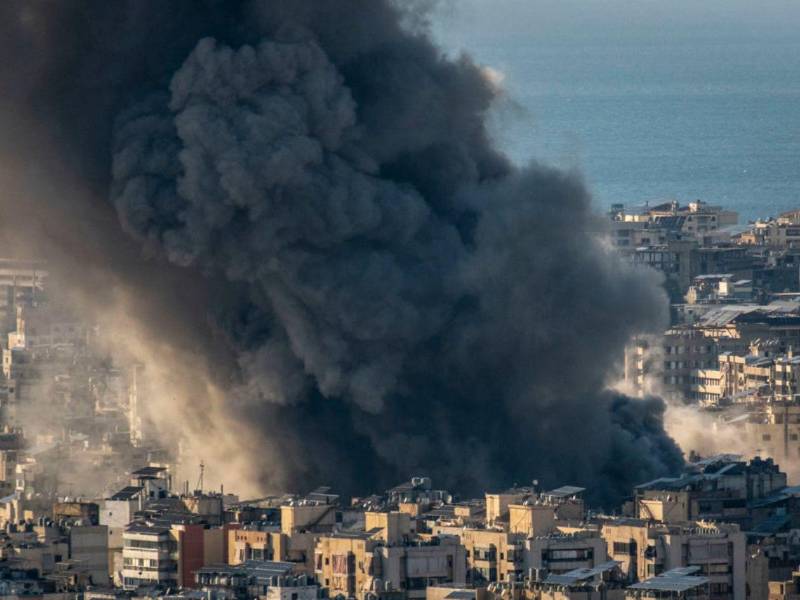 Una columna de humo se eleva tras ataques israelíes en el suburbio sur de Dahye en Beirut, Líbano, este pasado lunes. Las Fuerzas de Defensa de Israel (FDI) anunciaron este martes una nueva oleada de ataques contra Beirut, la capital del Líbano, con el objetivo de alcanzar cuarteles y depósitos de armas del grupo chiíta Hizbulá.