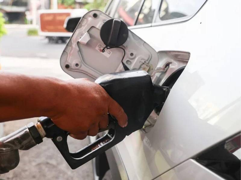 Persona cargando combustible en un automóvil color blanco.