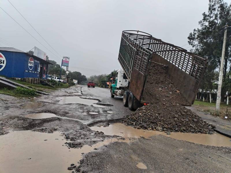 El mal estado de la carretera CA-13 ha obligado a empresarios locales a tapar los baches con arena.