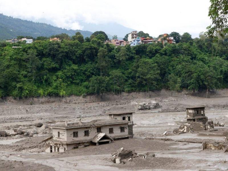 Las aguas de la inundación recorren Trishuli Bazar, en el distrito de Nuwakot, Nepal, el 26 de agosto de 2026, tras una riada repentina que causó destrucción en asentamientos e infraestructura.