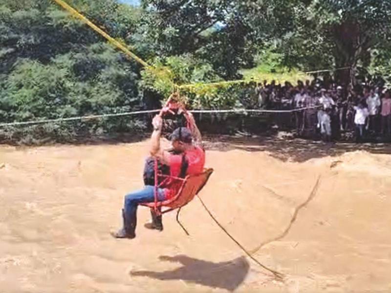 En una aldea de Danlí, El Paraíso, autoridades improvisaron un canopy, atando una cuerda y una silla para que las personas pudieran cruzar al otro extremo.