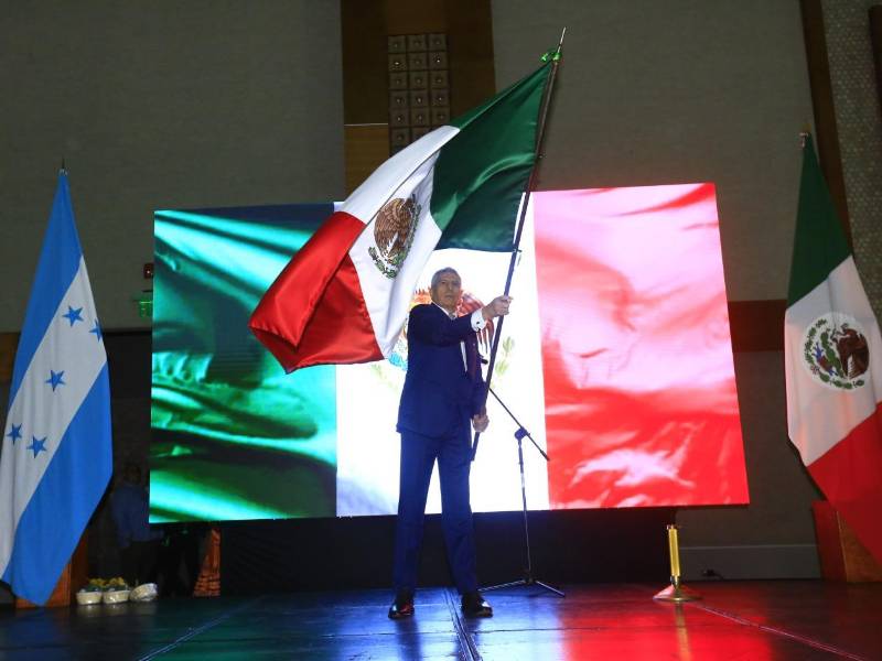 El cónsul Gilberto Limón ondeando la bandera mexicana, durante el Grito de Independencia de México.