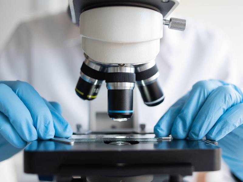 Fotografía de archivo que muestra a un científico que utiliza microscopio en laboratorio.