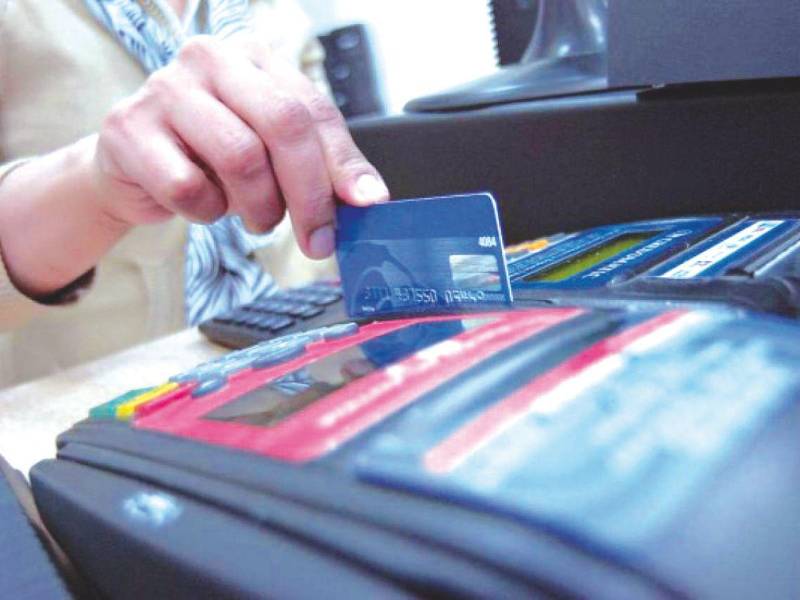 Un empleado de negocio desliza una tarjeta de crédito para realizar un cobro.