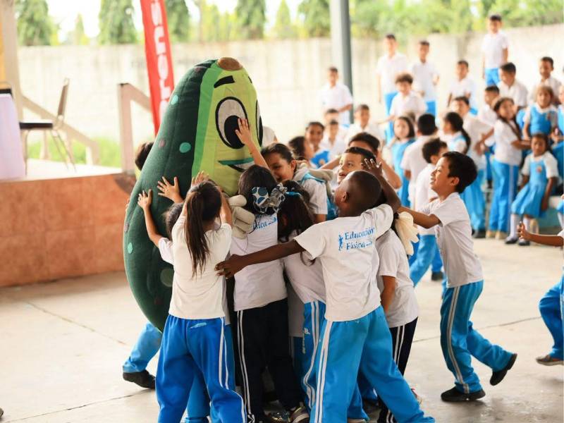 Niños abrazan a Aguacatín, la mascota de Supermercados Colonial.