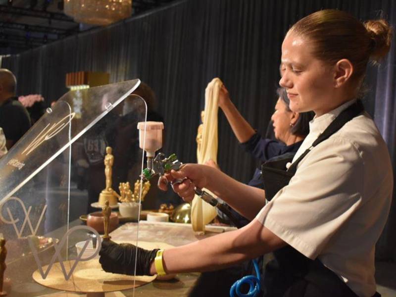 Una mujer decora una imagen de una estatuilla de los Óscar, en la ciudad de Los Ángeles (Estados Unidos).