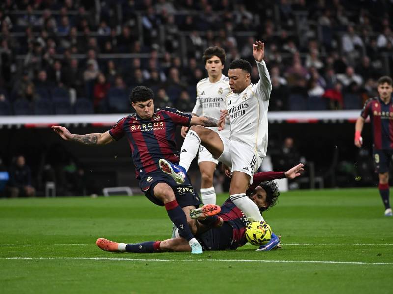 Kylian Mbappé disputando el balón con dos defensores del Levante.