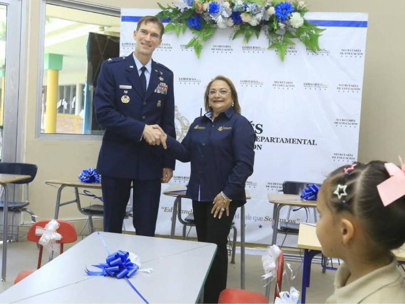 La ministra de Educación, Arely Argueta, junto a Paul Griffin, miembro del servicio militar estadounidense asociado a la distribución logística y de asistencia humanitaria durante el acto de entrega del mobiliario escolar.