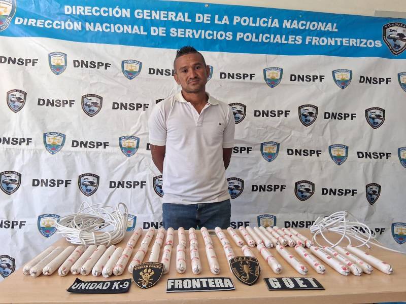 El detenido con los cartuchos de explosivos decomisados.