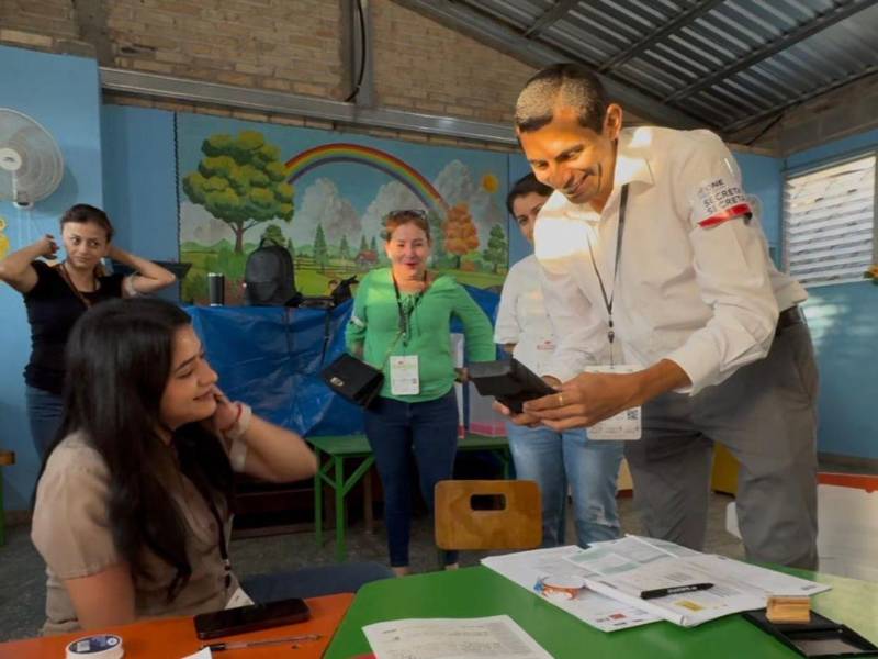 En el jardín Andrés H Barnica se le aplica el sistema biométrico a un votante.