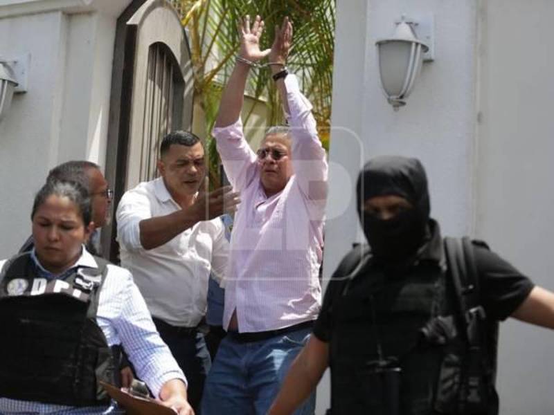 El periodista Esdras Amado López, enchachado por miembros de la Policía Nacional.