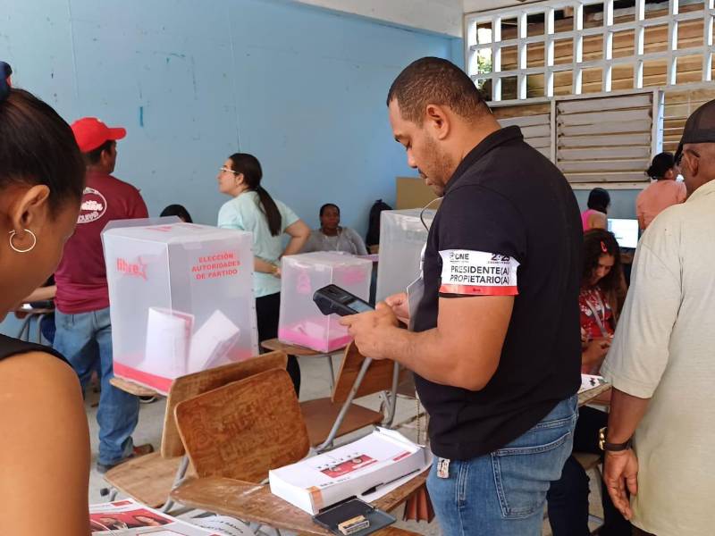 Los miembros de las Juntas Receptoras de Votos haciendo uso del dispositivo de identificación biométrica.