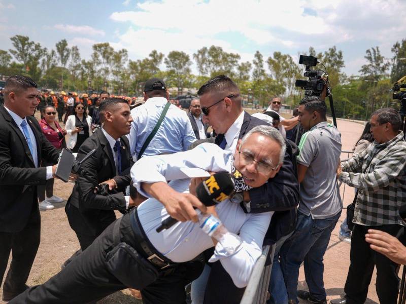 Momento en el que el periodista hondureño Edy Quintero, de TVC, es agredido por elementos de la Guardia de Honor Presidencial.