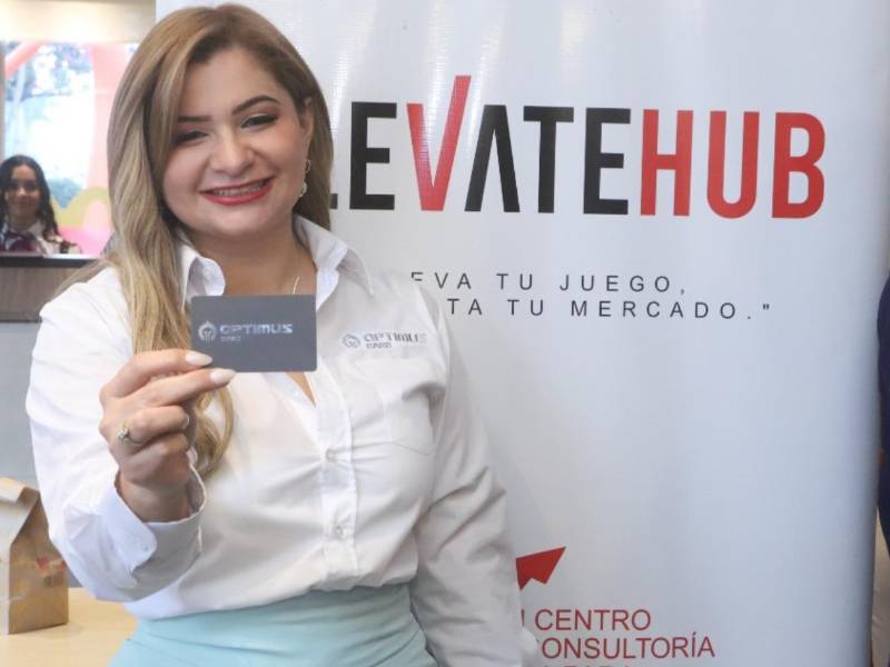 Máster Emma Mejía Valladares mostrando la tarjeta de Optimus Card durante la presentación del convenio.