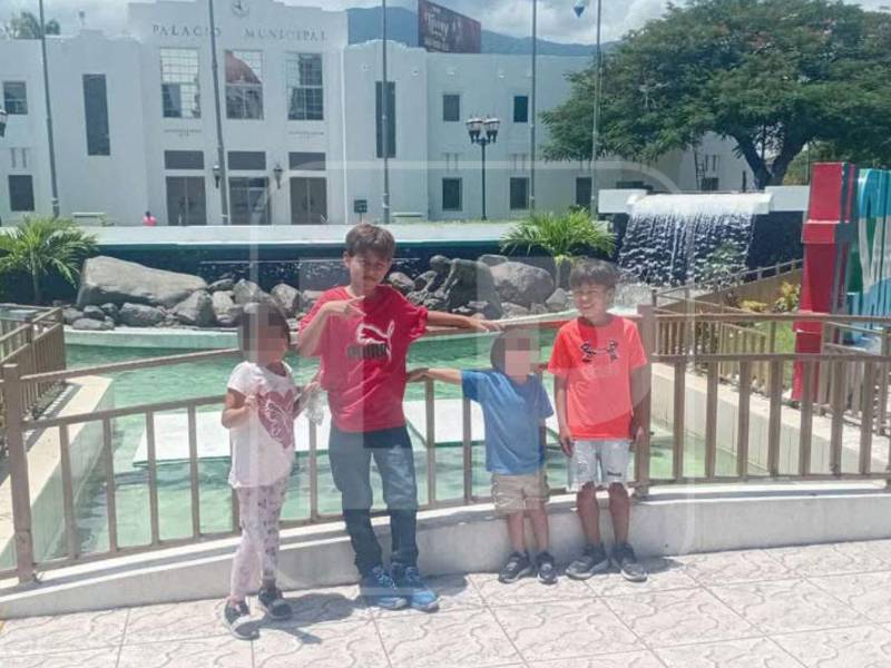 Elvis Eliú (de rojo), su hermanito Erick (de naranja) y otros dos niños en el parque central de San Pedro Sula, en una imagen de recuerdo.