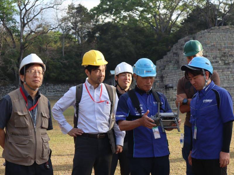 Seiichi Nakamura (izquierda), director del Centro de Estudios de la Arqueología de la Próxima Generación de la Universidad de Komatsu, con los expertos de Yamaha Motor en Copán al sobrevolar con un drone el parque arqueológico de Copán.