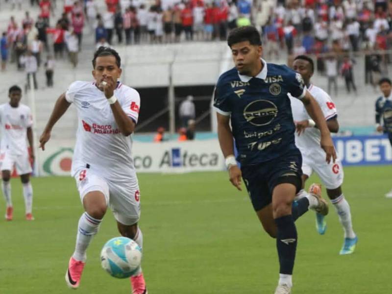 Clever Portillo del Motagua en la disputa del balón con Edwin Rodríguez de Olimpia.