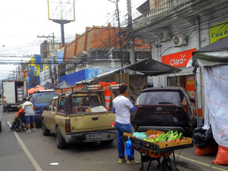 El lente de Diario LA PRENSA captó el momento en que un ciudadano trasladaba a una persona en silla de ruedas por la calle, debido a que los vehículos mal estacionados bloqueaban el paso por la acera.