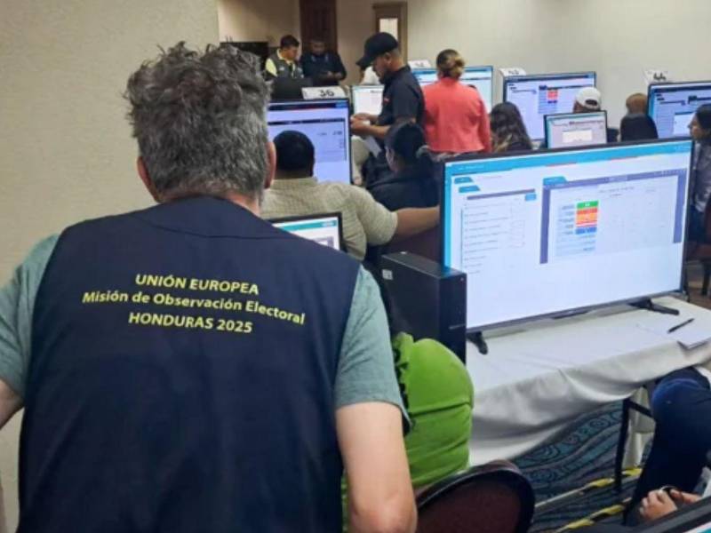 Personal de la Misión de Observación Electoral de la Unión Europea revisan el sitio de resultados electorales del CNE en Tegucigalpa.