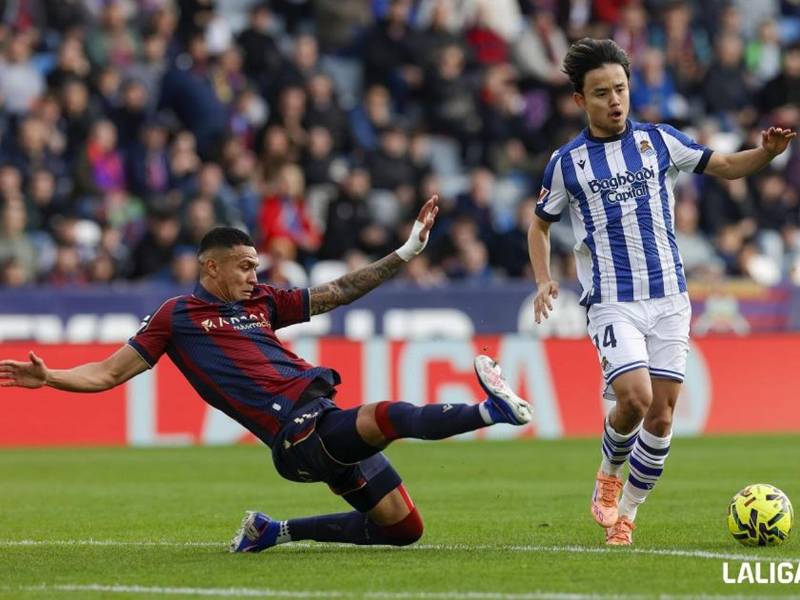 Kervin Arriaga se barre para buscar robarle el balón al japonés Take Kubo.