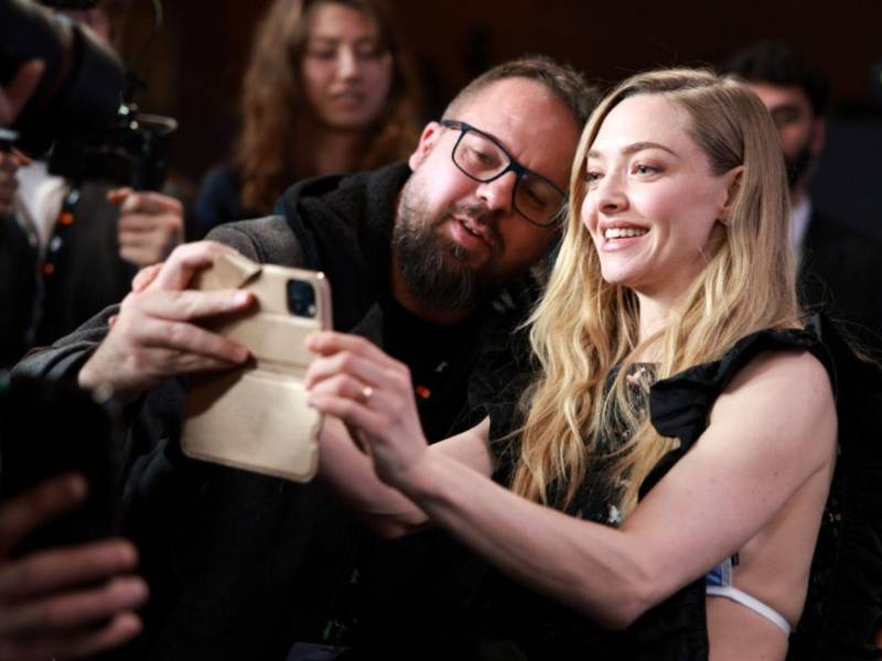 La actriz estadounidense Amanda Seyfried se toma un selfie con un fan y miembro de la prensa al final de una conferencia de prensa para 'The Testament of Ann Lee' durante el 76º Festival Internacional de Cine de Berlín, en Berlín, Alemania.