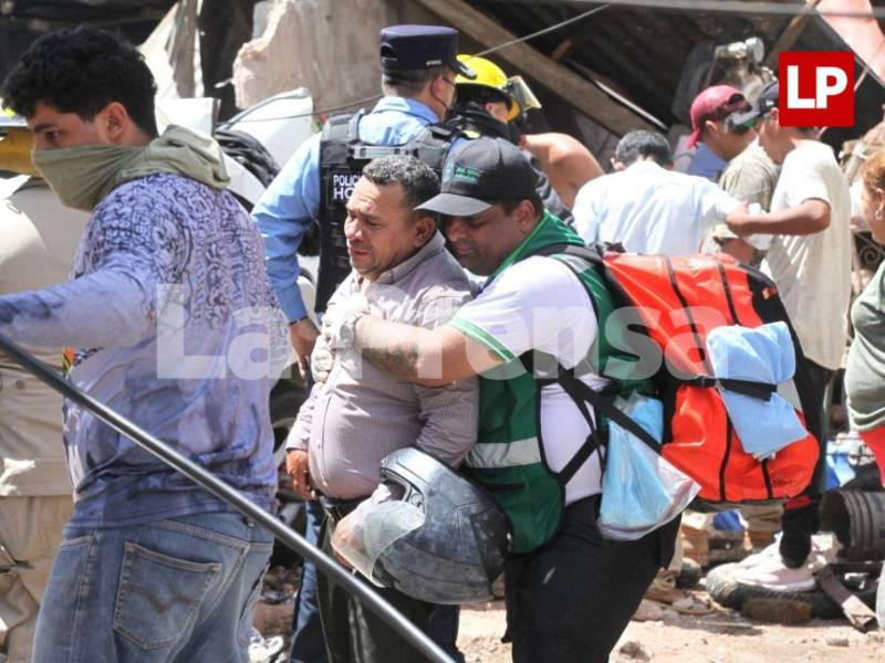 El padre de Evelin Irías llora en la escena del accidente mientras es consolado por un socorrista de la Cruz Verde Hondureña.
