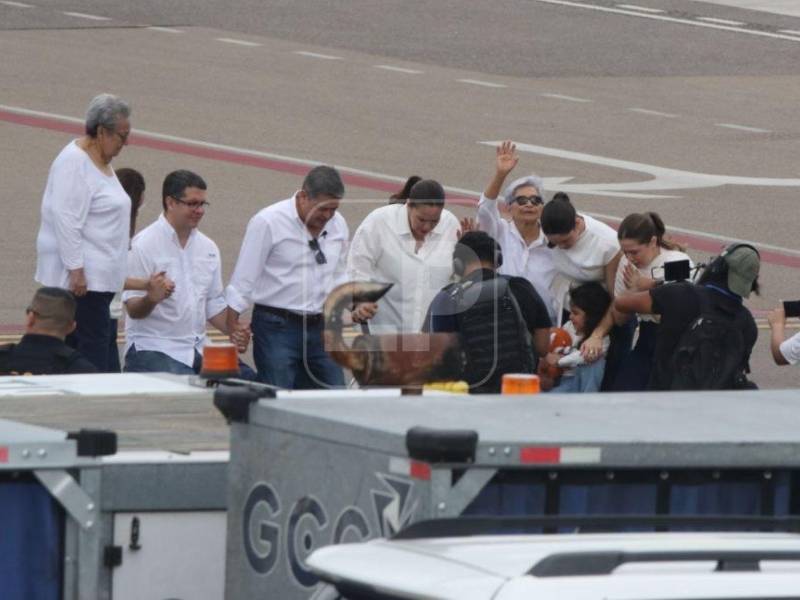 El expresidente Juan Orlando Hernández ora junto a su esposa, Ana García de Hernández, sus hijas y otros familiares cercanos tras descender de la aeronave en la pista del Aeropuerto Internacional de Palmerola.