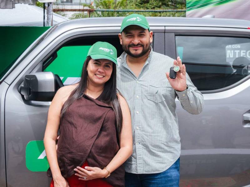 Angelo Meléndez y su esposa posan con alegría frente al KIA Tasman en el momento de recibir las llaves, durante el acto de entrega de Puma Energy.