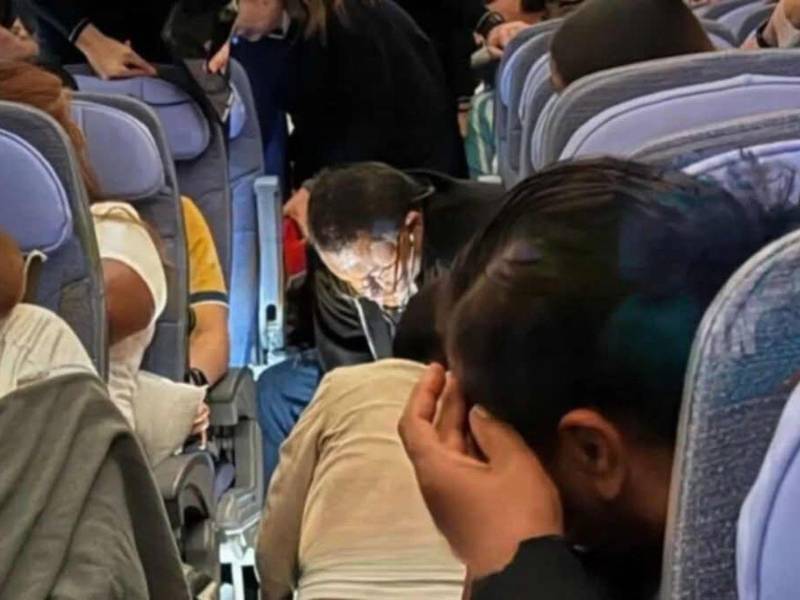 El doctor Carlos Umaña y la doctora Tirsa López realizando reanimación a una paciente de 70 años durante un vuelo hacia Madrid, España.