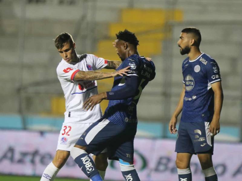 Agustín Mulet del Olimpia empuja a Riky Zapata de Motagua al momento del cobro de un tiro de esquina.