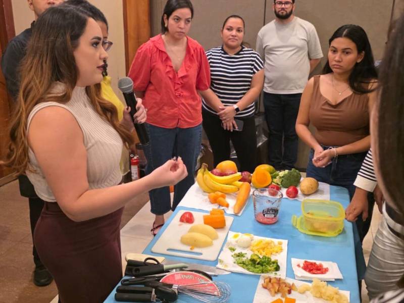 La doctora Gabriela López enseña a padres de familia sobre porciones y alimentos que los niños pueden consumir según su edad.